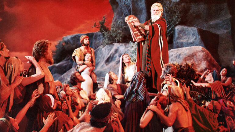Charlton Heston as Moses holding inscribed stone tablets, alongside John Derek as Joshua, Debra Paget as Lilia and Yvonne De Carlo as Sephora, in Cecil B. DeMille's The Ten Commandments (1956)