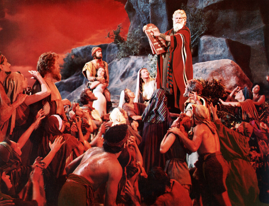 Charlton Heston as Moses holding inscribed stone tablets, alongside John Derek as Joshua, Debra Paget as Lilia and Yvonne De Carlo as Sephora, in Cecil B. DeMille's The Ten Commandments (1956)