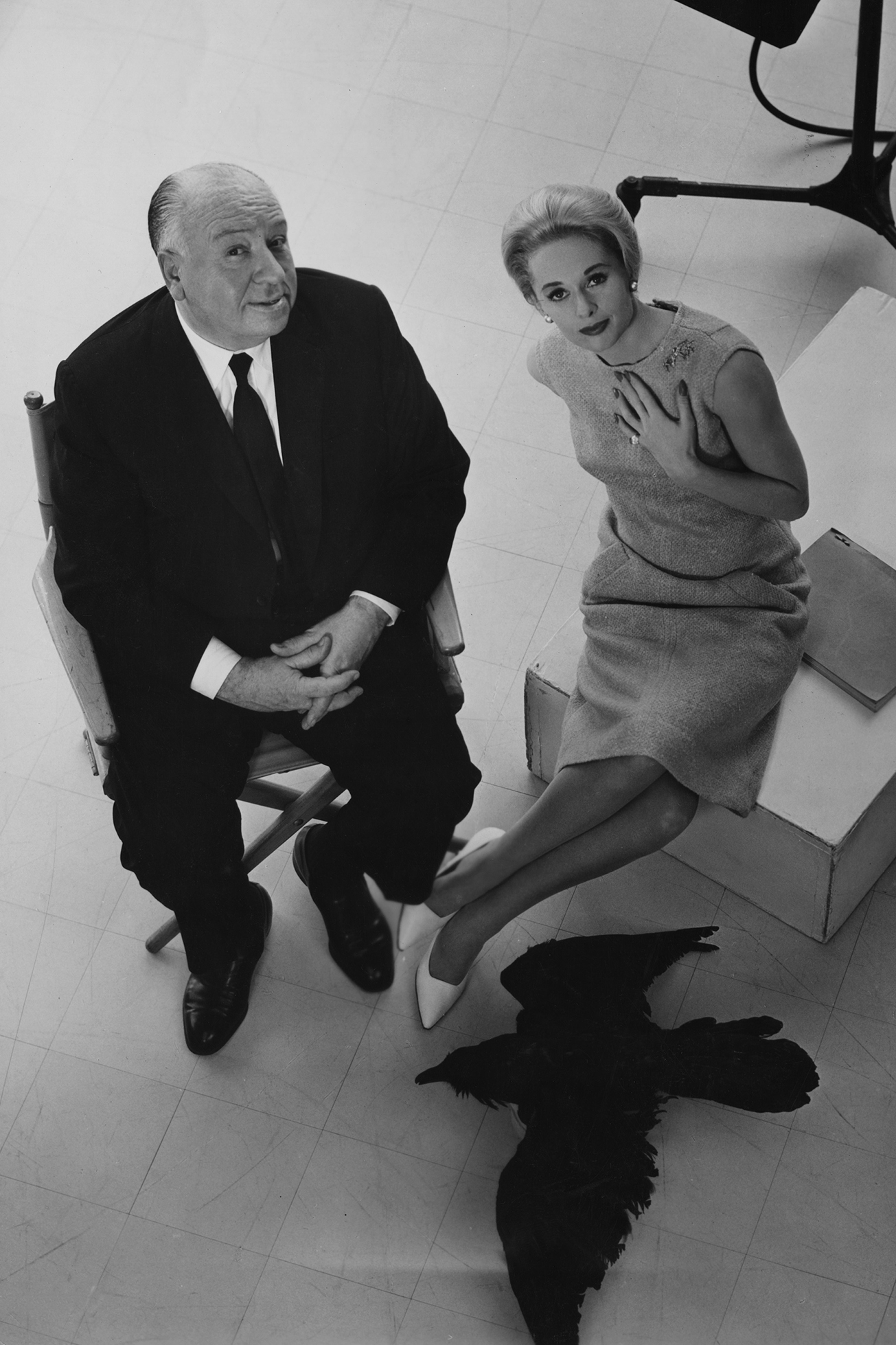 Director Alfred Hitchcock (1899 - 1980) and leading lady Tippi Hedren pose with a stuffed raven on the set of the film 'The Birds, 1963. 