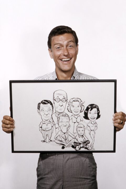 THE DICK VAN DYKE SHOW, Dick Van Dyke, with a caricature he did of cast members (from left) Morey Amsterdam, Richard Deacon, himself, Rose Marie, Larry Mathews, Mary Tyler Moore, 1964