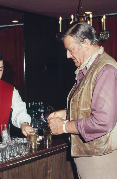 LOS ANGELES - JULY 1971: John Wayne buys a few drinks at a charity costume party in July 1971 in Los Angeles, California.