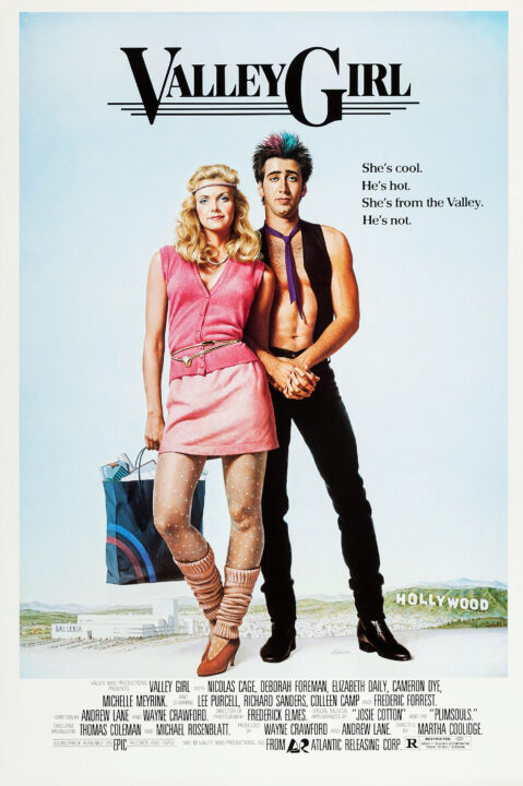 A promotional movie poster for the 1983 romantic comedy/drama "Valley Girl." The film's title is right at the top of the poster, in black lettering, with the "V" in "Valley" and the "G" in "Girl" standing out from the other letters in a larger font. Below the title, standing, are illustrations of the film's stars: On the left, Deborah Foreman as Julie, dressed as a typical early '80s "valley girl," almost entirely in pink, wearing an early '80s style dress with stockings, leg warmers, heeled shoes and a headband. She is holding a filled shopping bag, and off in the distance behind her and a little lower is an illustration of L.A.'s Galleria mall. She is mostly balanced on her left leg, with her right leg bent a bit and left hip out. She is standing very close, and touching, Nicolas Cage's character Randy, who is dressed in black pants and boots, and with only a thin black best and thin purple tie on his upper body, no shirt. His hair is spiky, mostly black but with tints of purple and blue in the center for a punky look. His hands are clasped together in front of him, and Foreman's left arm is reaching between them, with her left hand clasping both of his hands together in an intimate way. Behind and below Cage, in the distance, is the Hollywood sign. Both characters are looking ahead confidently. Below them the credits for the film are listed, its title, stars, director, production company, rating (R), all in black lettering.