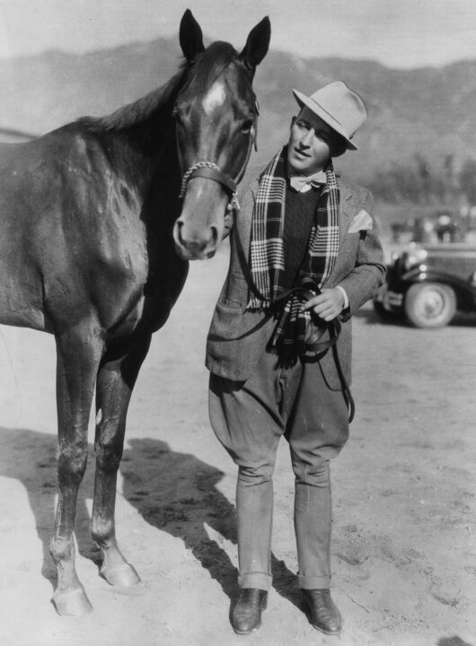 Crooning movie star and on of stable-to race at Santa Anita.Los Angeles, Calif … Bing Crosby, famous crooning star of the movies, shown with his favorite racehorse, "Khayym", one of the many in his stable now at the Santa Anita racetrack which opened yesterday December 25th. Bing is HollywoodS outstanding owners and will spend all of his spare time supervising the racing of ponies. Credit: International News Photo Central Press Association December 27, 1935