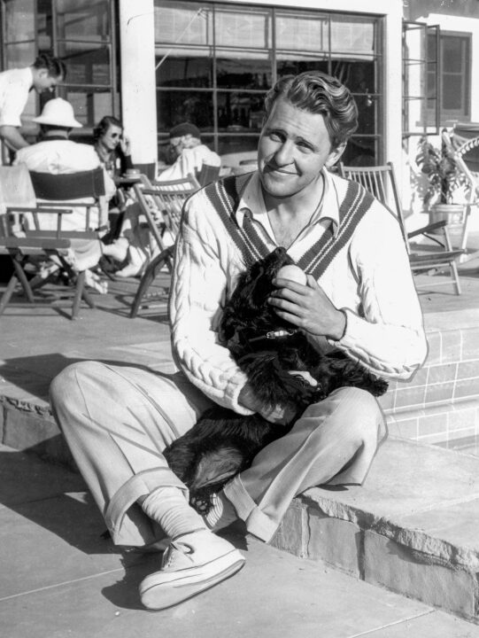 Jack Alblin International News Photos Movie ServiceSeated on the edge of the pool and playing with his pet scotty is Ralph Bellamy, film star. Bellamy is half owner of a desert sports club with Charles Farrell, screen player as his partner. the two of them have transformed the desert near Palm Springs in to an exclusive rendezvous for members of the movie colony. The two stars have already invested over $50,000 dollars in the place and are still improving it. Central Press Assoc. Jan. 19, 1939
