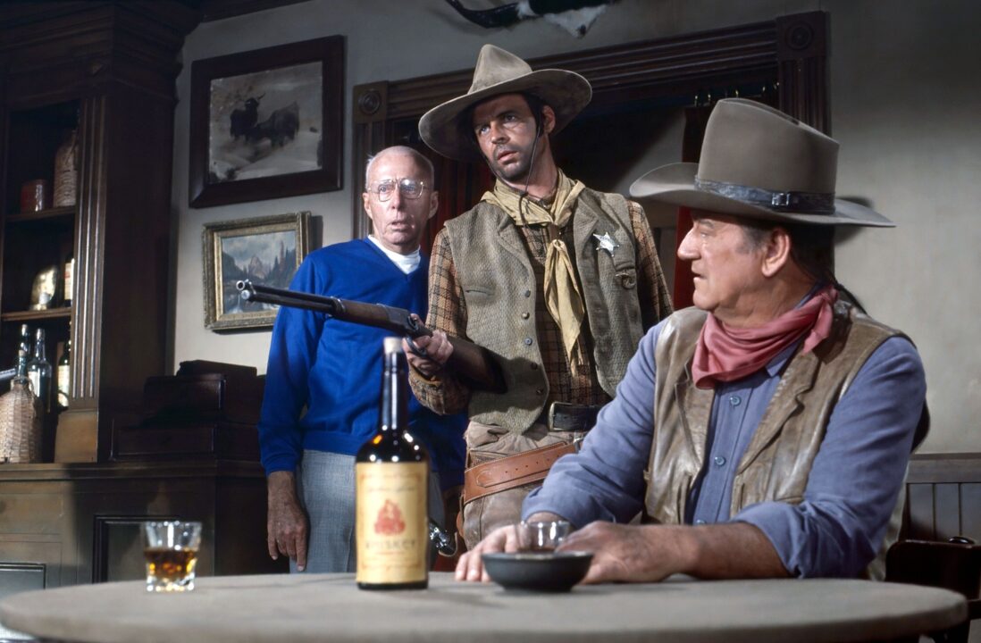 RIO LOBO, from left: Director Howard Hawks, George Plimpton, John Wayne, on set, 1970.