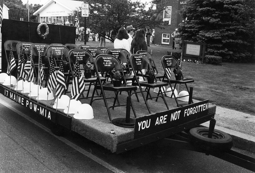 GRAY, ME - MAY 28: 17 empty black painted chairs with 17 helmets and 17 flowers at Gray's Memorial Day parade and ceremonies May 28, 1991, represent Maine's 17 POW/MIAs still unaccounted for.