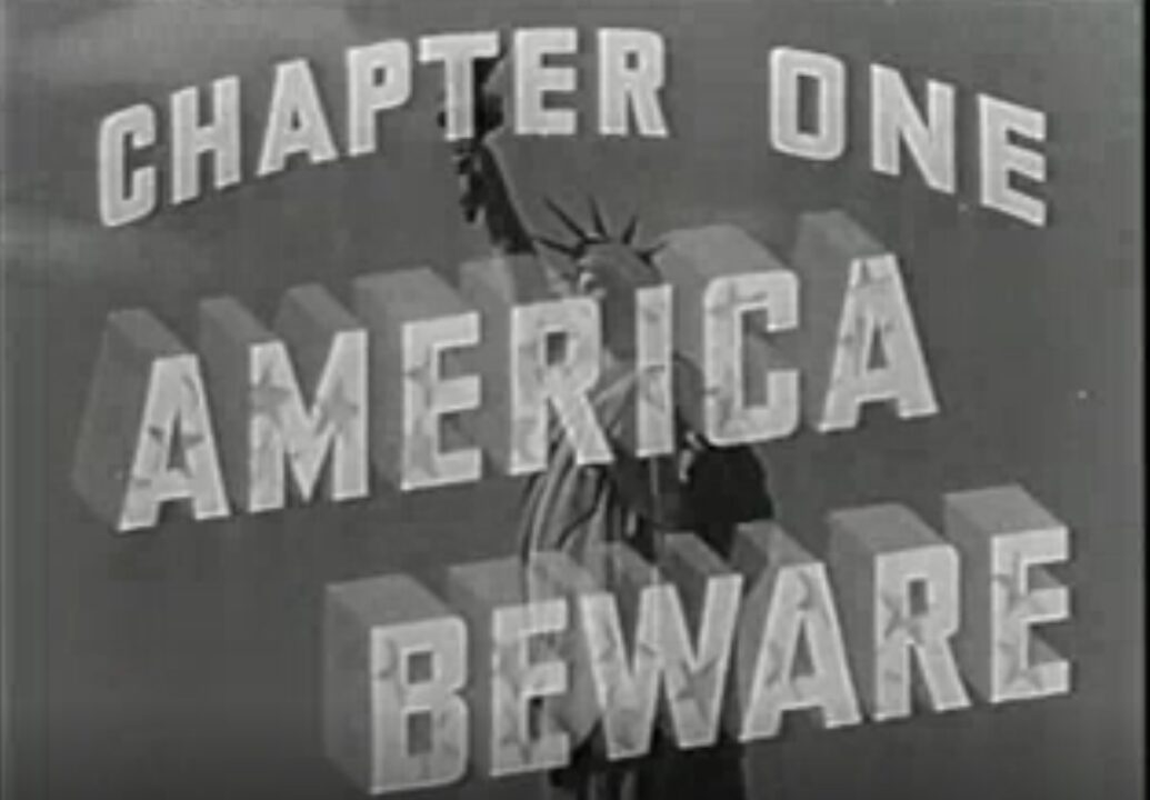 Chapter One title card for the 1942 movie serial "Spy Smasher." It reads "Chapter One: America Beware" superimposed over a picture of the Statue of Liberty