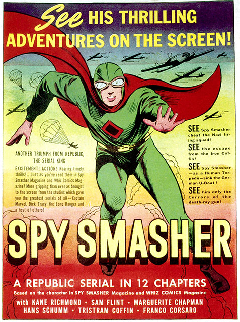 movie poster for the 1942 movie serial "Spy Smasher." It is a color illustration depicting the hero rushing toward the viewer of the poster, wearing a green costume with red cape, a leather helmet and aviator goggles, with the title "Spy Smasher" just beneath him. Above him reads text: "See his thrilling adventures on the screen!"
