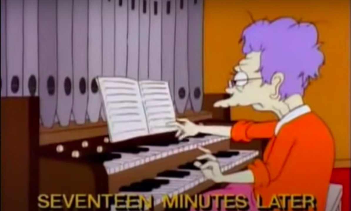a scene from the 1995 "Bart Sells His Soul" episode of "The SImpsons." It shows an elderly woman playing an organ in church after being tricked by Bart Simpson into playing the 17-minute-long rock track "In-A-Gadda-Da-Vida." The woman looks exhausted at trying to keep up, and a caption at the bottom reads: "Seventeen Minutes Later."