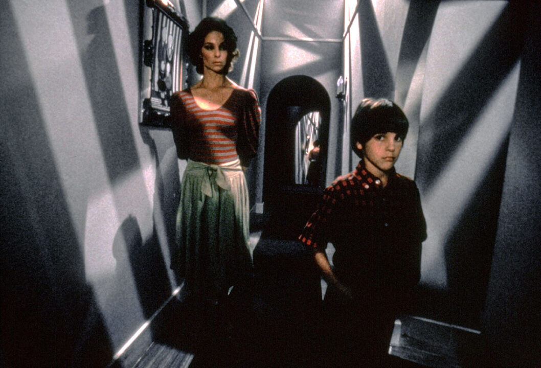 Kathleen Quinlan and Jeremy Licht in "Twilight Zone: The Movie." The still is from the movie's third segment, based on the Twilight Zone episode "It's a Good Life," about a boy with monstrous psychic powers to transform people and his surroundings. The two are standing in an oddly angled hallway in the house the boy has created with his mind.