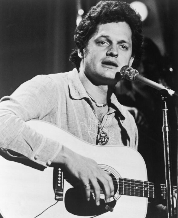 American singer-songwriter Harry Chapin (1942 - 1981) plays the guitar and sings on stage during a performance, 1970s. 