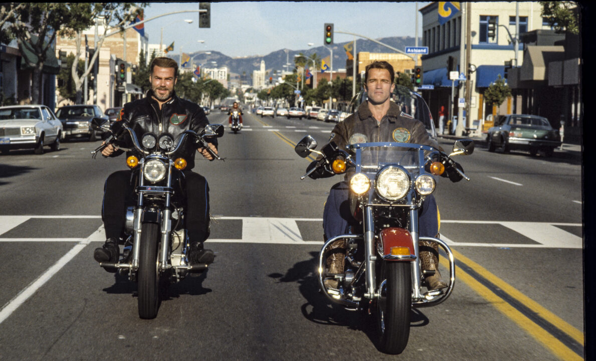 Arnold Schwarzenegger and Sven Ole Thorsen cruising on their motorbikes on Venice Boulevard, California, United States, 1989