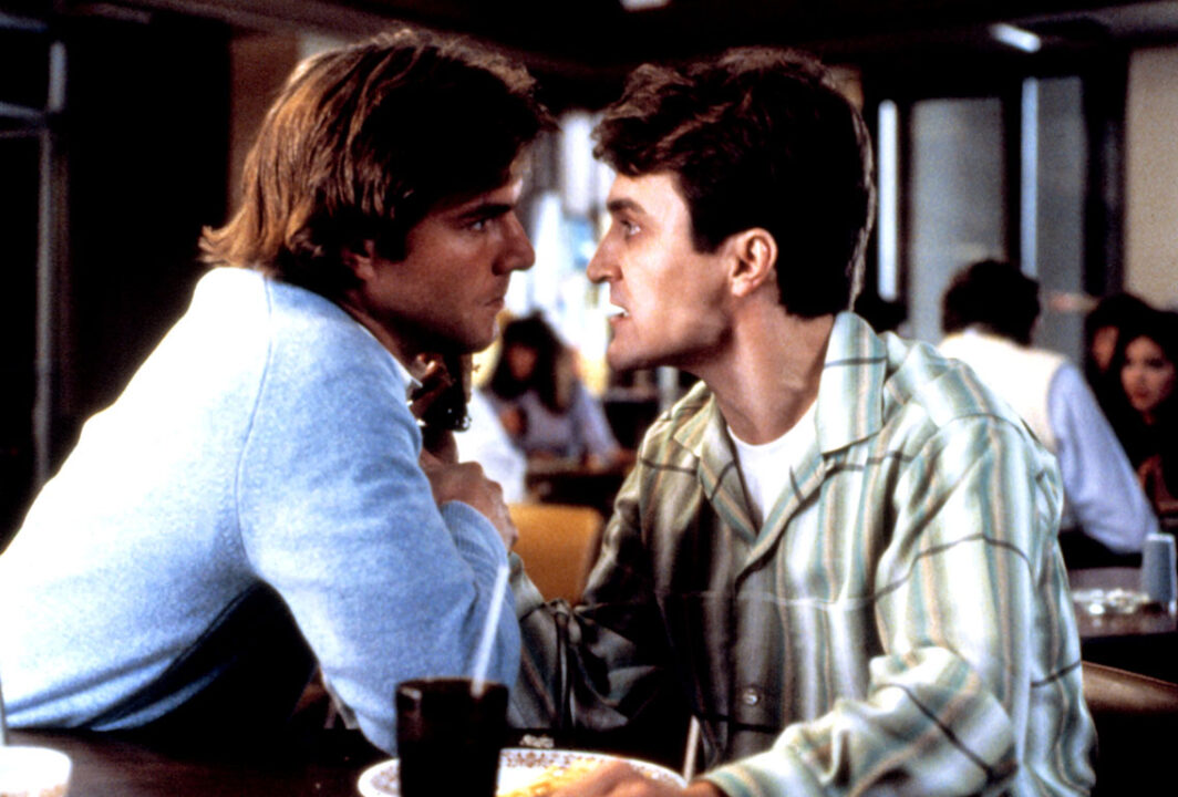 scene from the 1984 movie "Dreamscape" It depicts Alex Gardner (Dennis Quaid) on the left, sitting at a lunch table and angrily confronting rival psychic Tommy Ray (David Patrick Kelly). Both men are nearly nose-to-nose in their clearly heated conversation.