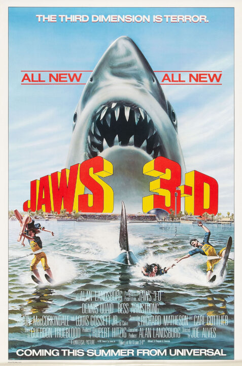 movie poster art for the 1983 film "Jaws 3-D." The illustration is of two teams of water skiers being pulled in front of an audience at a Sea World type location. A member of the team on the right of the photo, a woman who had been held up high by the man, has fallen into the water and looks terrified because a large dorsal fin of a shark is quickly approaching. Above them, to the back of the photo, reads the title "Jaws 3-D" in red lettering looking as if it is coming out of the poster in 3-D. Above that is the famous "Jaws" image of the shark swimming upward with its teeth bared. Above the shark, in white lettering across the blue sky, reads: "The third dimension is terror."