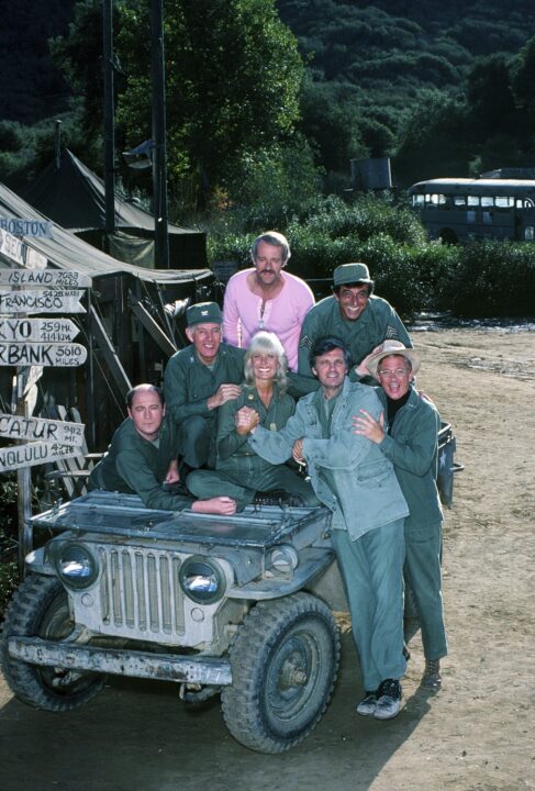 MASH, (aka M*A*S*H*), from left: David Ogden Stiers, Harry Morgan, Loretta Swit, Mike Farrell (pink), Alan Alda (front), Jamie Farr, William Christopher, ph: 1982