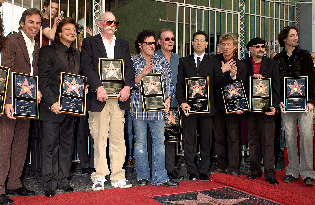 (L-R) Rock group Journey bandmembers Jonathan Cain, Steve Perry, George Tickner, Neal Schon, Aynsley Dunbar (rear), Robert Fleischman, Ross Valory, and Steve Smith (beret) at their star ceremony where they were honored on the Hollywood Walk of Fame