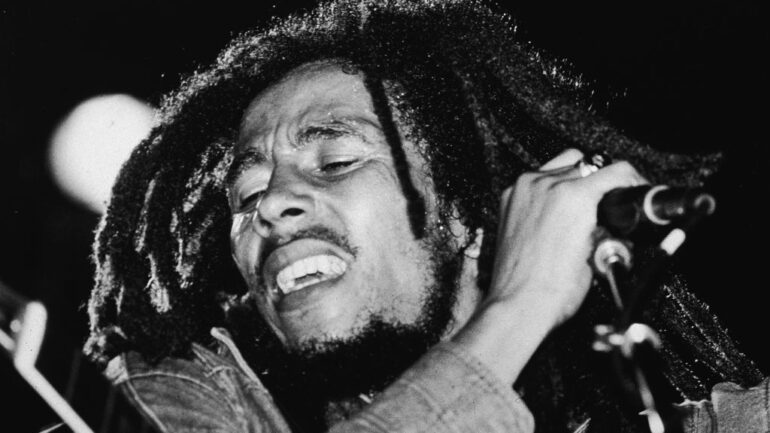 Jamaican reggae musician Bob Marley (1945 - 1981) performs on stage, a microphone in his hand, late 1970s