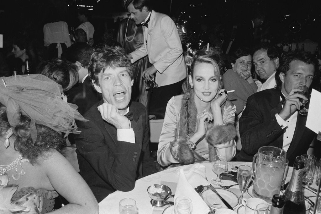 English singer, songwriter, actor, and film producer Mick Jagger and American model and actress Jerry Hall attend the Berkeley Square Ball, London, UK, 17th July 1984