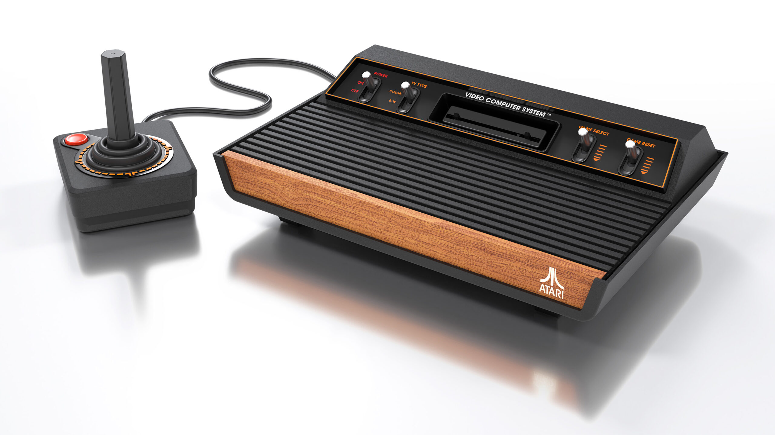 image of the Atari 2600+ video game console, with attached joystick controller. It is a re-creation of the version of the original Atari 2600 console released in 1980, with four metal switches and wood panel.