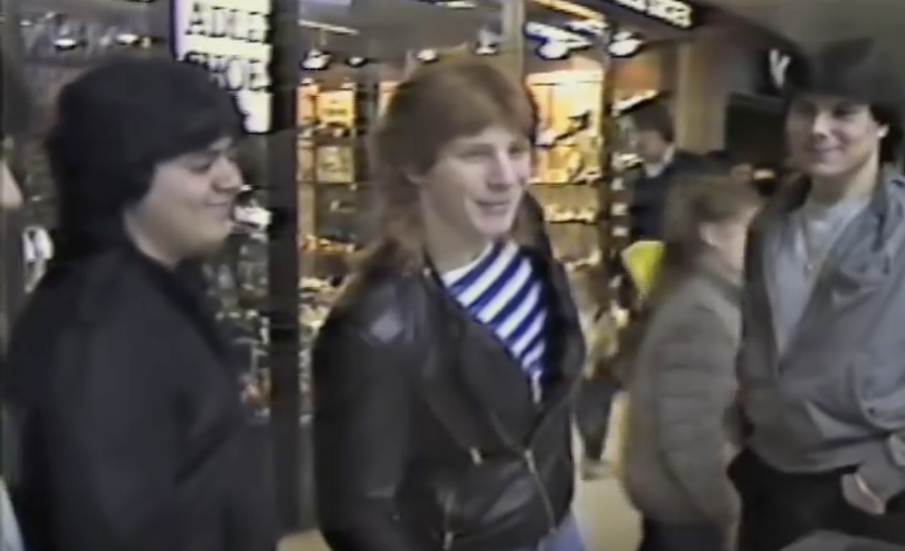 screenshot from the 1983 video documentary "Mall City." It pictures three teenage boys in leather jackets hanging out at a Long Island shopping mall.