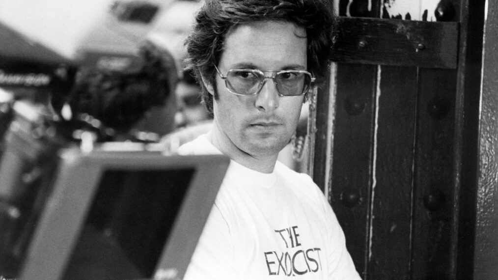 a black-and-white behind-the-scenes photo of director William Friedkin on the set of 