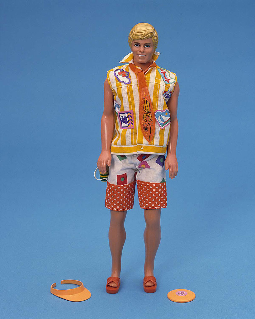 studio portrait of a 1998 California Dream Ken doll by Mattel. Ken has blond hair and is wearing a '90s style beach shirt and shorts