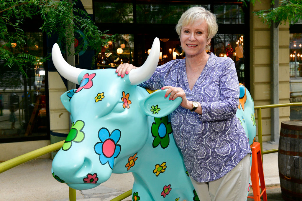 BROOKLYN, NEW YORK - AUGUST 05: Artist Eve Plumb poses with her "Daisy" painted cow on display at the CowParade 2021 launch event hosted by God’s Love We Deliver at the Artist Studio sponsored by CLEAR in Industry City on August 5, 2021 in Brooklyn, NY