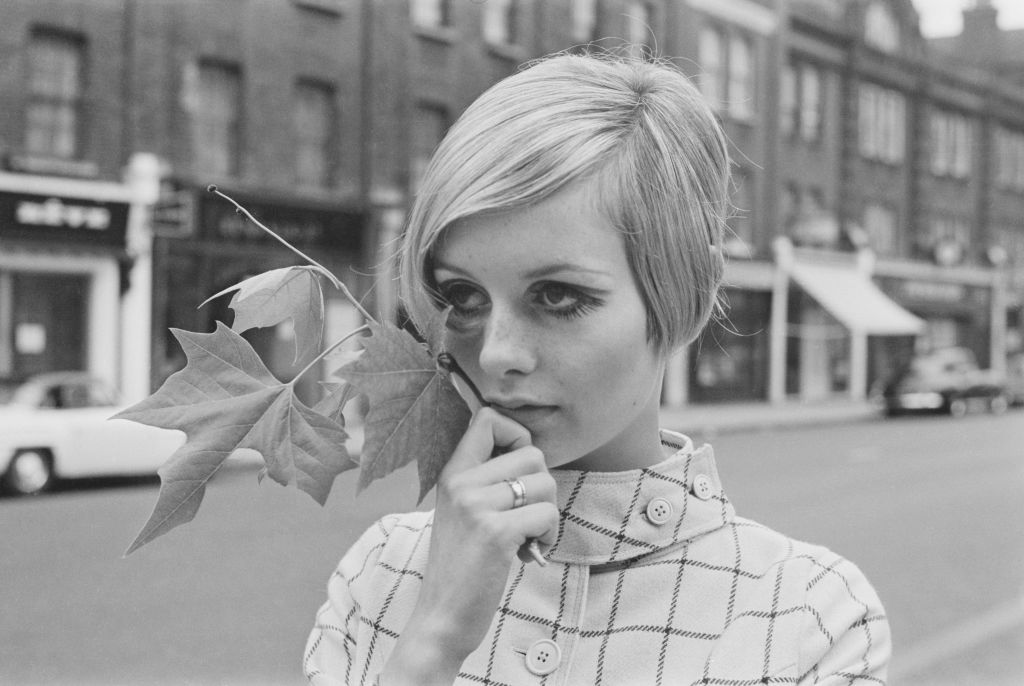 English model, actress, and singer Twiggy holds a maple leaf while standing in the middle of King's Road in Chelsea, London, UK, 13th June 1966