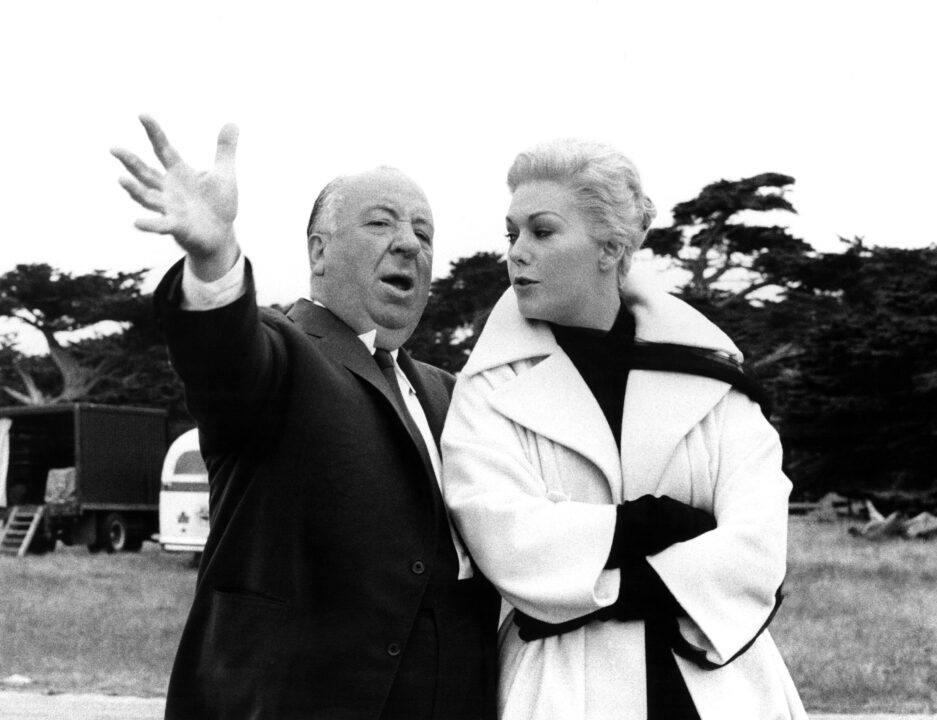 VERTIGO, Director Alfred Hitchcock hams it up on set with Kim Novak, 1958