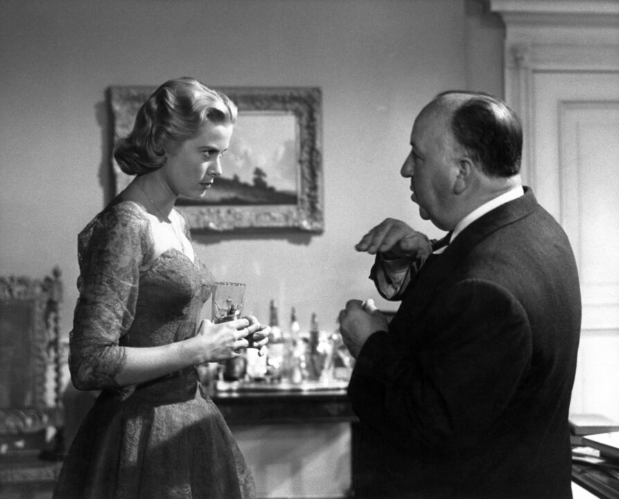 DIAL M FOR MURDER, Grace Kelly with director Alfred Hitchcock on set, 1954