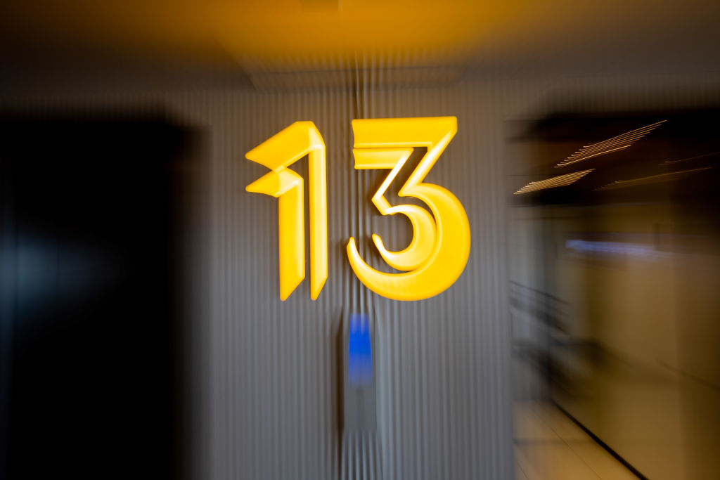 28 April 2022, Berlin: The number 13 hangs on the elevator on the 13th floor in a building. (Posed scene, wipe effect by zooming)