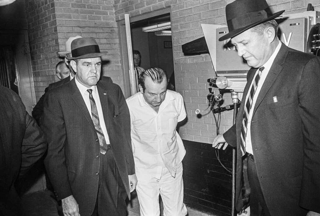 Police officers escort Jack Ruby, killer of accused presidential assassin Lee Harvey Oswald, from the Dallas City Jail to a county facility in Texas. It was during just such a transfer that Ruby shot Oswald. 