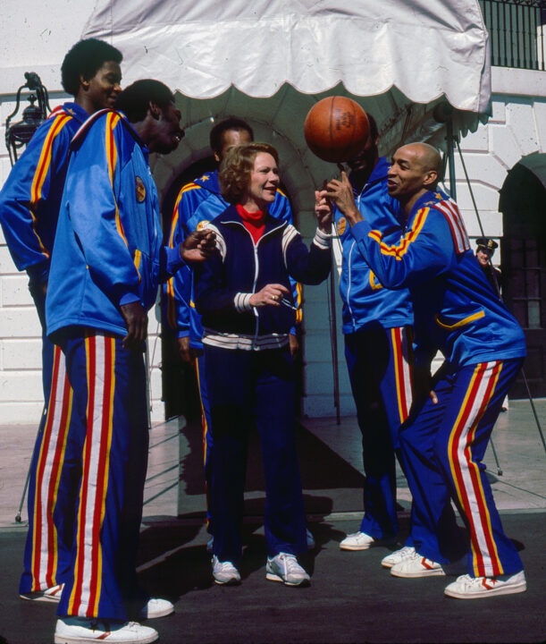US First Lady Rosalynn Carter plays basketball with members of the Harlem Globetrotters outside the White House, Washington DC, March 1980. They are teaching her how to spin a basketball on her fingertip. 