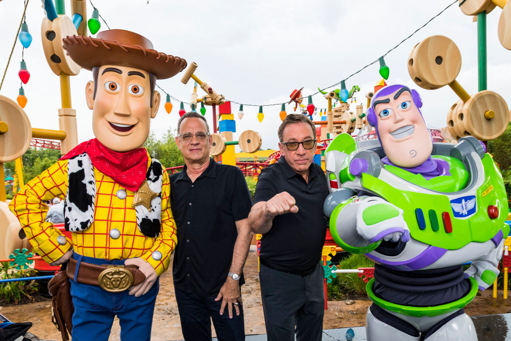 LAKE BUENA VISTA, FLORIDA - JUNE 08: In this Handout provided by Disney Resorts, Stars from DisneyPixars Toy Story 4 Woody (in costume), Tom Hanks (2nd-L), Tim Allen (2nd-R) and Buzz Lightyear (in costume) appear with characters from the film inside Toy Story Land at Disneys Hollywood Studios at Walt Disney World Resort on June 8, 2019 in Lake Buena Vista, Florida