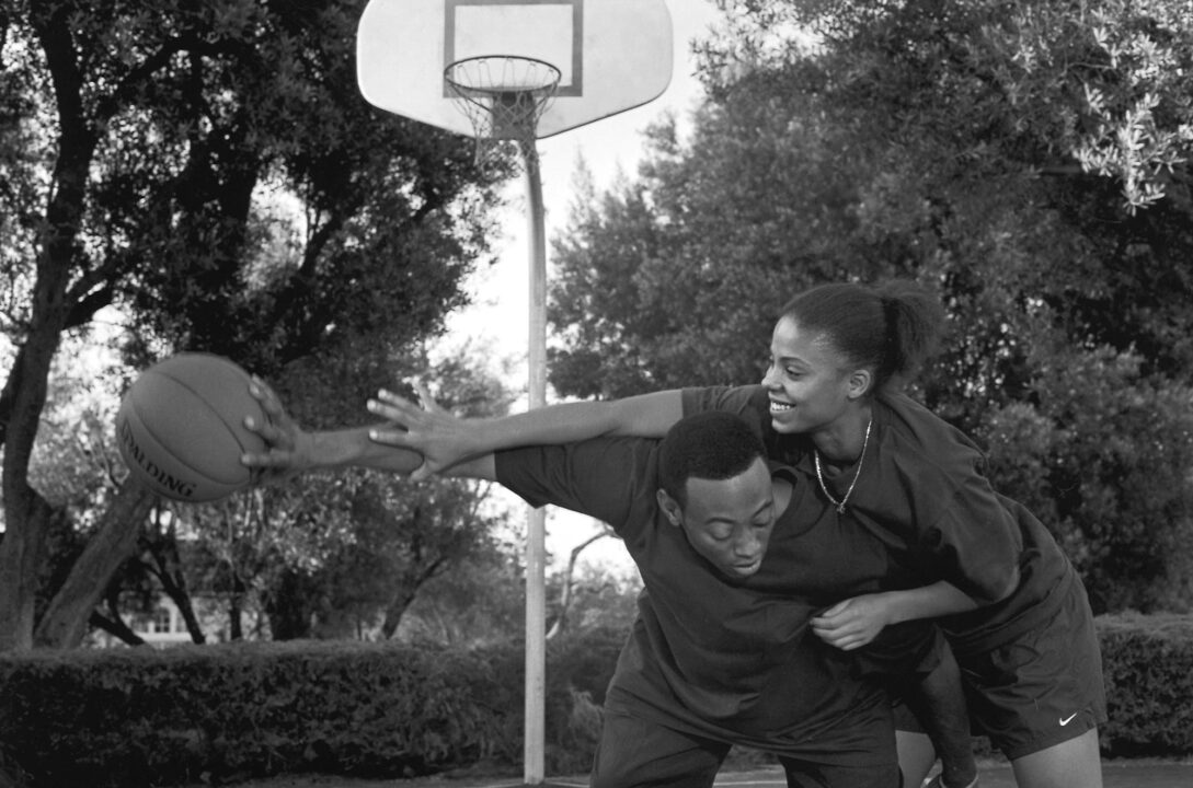 image from the 2000 film "Love & Basketball." Sanaa Lathan and Omar Epps' characters are laughing as they go one-on-one at basketball.