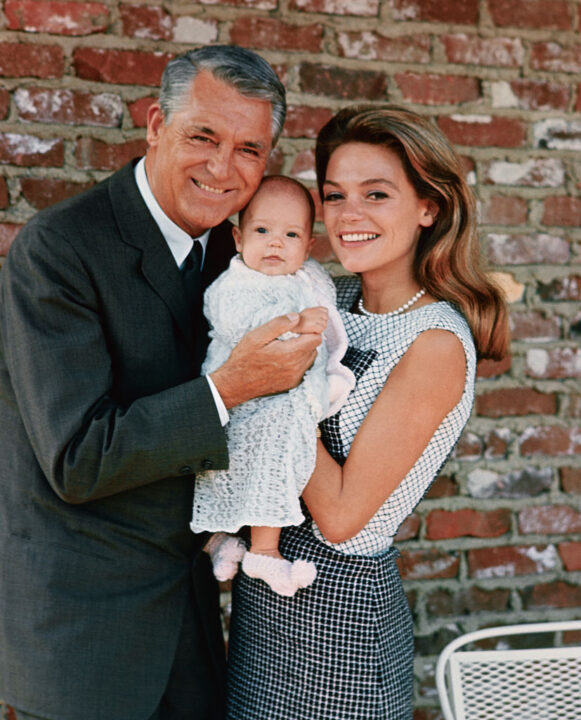 (Original Caption) Jennifer Grant, 3 1/2-months-old, wears a big smile for the cameraman as she makes her debut with her famous parents. The family is pictured together for the first time prior to their departure for England, where they will visit Grant's mother. Cary recently completed the starring role in Columbia's Walk, Don't Run.