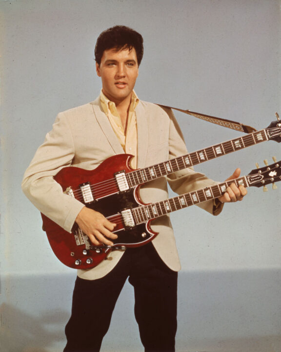 Portrait of American singer and actor Elvis Presley (1935 - 1977) holding a 1965 Gibson EBS-1250 Double Bass (a combined 6-string and bass guitar), circa 1966. Elvis is seen playing the guitar in his 1966 film, 'Spinout'
