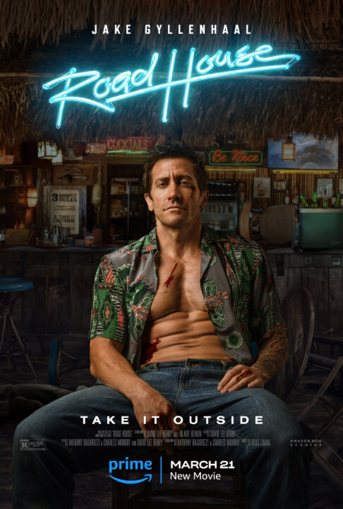 poster from the 2024 Prime Video movie "Road House," a remake of the 1989 film. It shows a photo illustration of star Jake Gyllenhaal sitting on a bar stool and facing away from the bar. He is wearing a Hawaiian shirt that is completely unbuttoned, exposing his chest and well-developed ab muscles. He is wearing jeans, his legs are spread a bit, and he is sitting back with a confident expression on his face. Above him, in blue neon light lettering, reads the title "Road House." Across Gyllenhaal's knees are the words "Take It Outside" in white lettering.