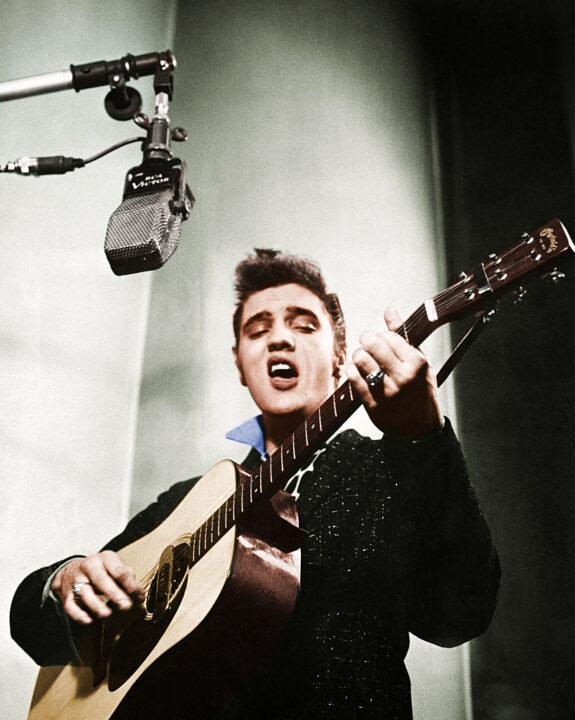1/1956-Close up of Elvis Presley playing guitar.