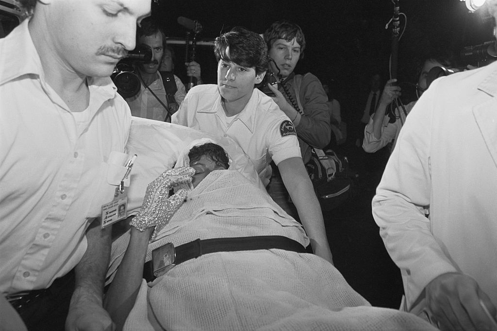 Paramedics wheel Michael Jackson into Brotman Memorial Hospital after being burned during the filming of a Pepsi commercial. Exploding fireworks set his jacket and hair on fire giving him second degree burns on his scalp. | Location: Brotman Memorial Hospital, Los Angeles, California, USA.