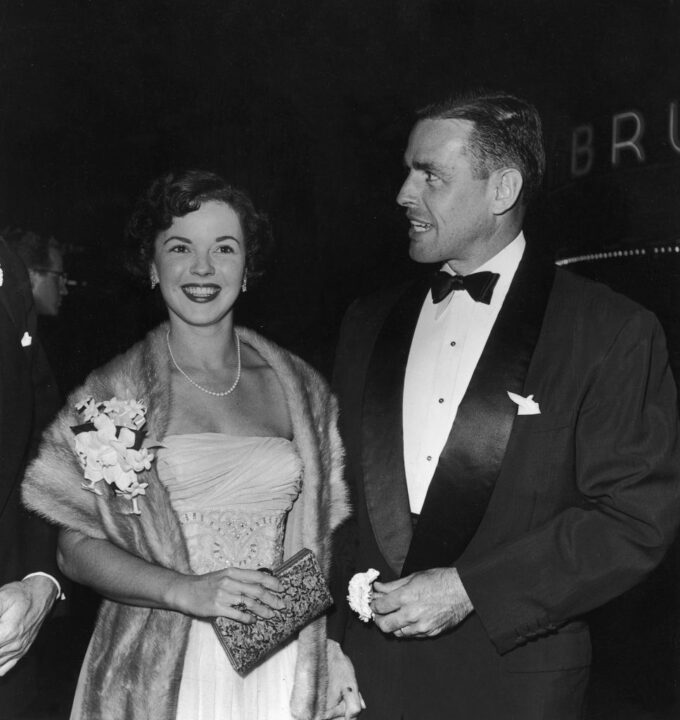 1953: American actor Shirley Temple and her husband, Charles Black, pose together at the premiere of director William Wyler's film, 'Roman Holiday'. Temple wears a mink stole over a strapless dress. Black wears a tuxedo