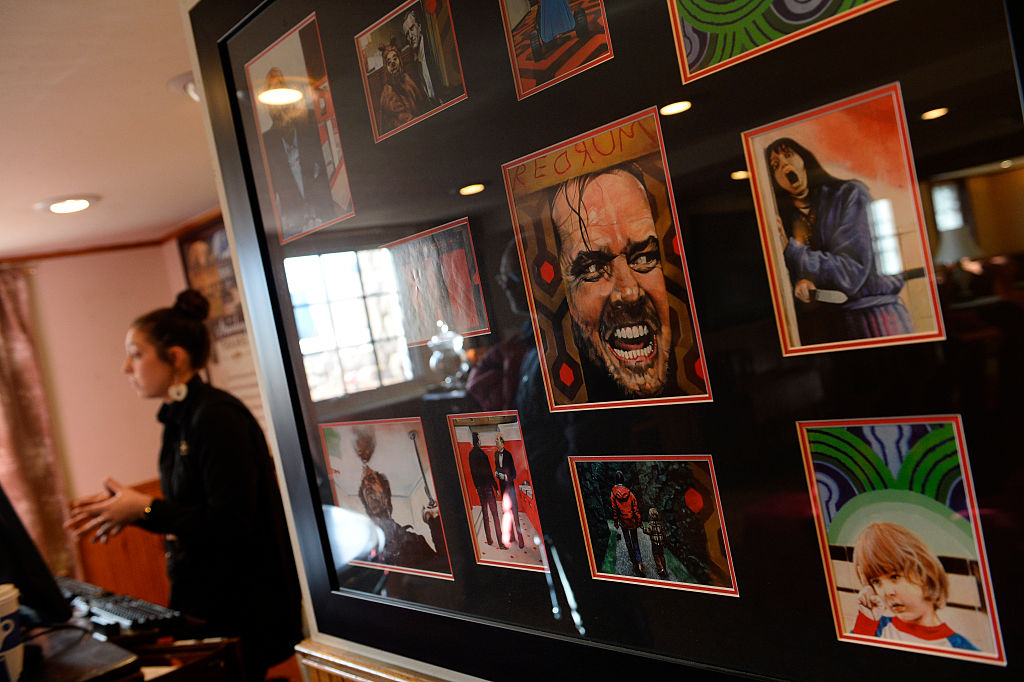 Tour guide Jofia Ross, left, talks to visitors next to a display of movie memorabilia from the popular movie "The Shining" at the Stanley Hotel on January 12, 2016 in Estes Park, Colorado. She is affectionately called Lady J. The Stanley Hotel, which first opened in 1909, and known for its architecture, magnificent setting, and famous visitors, may possibly be best known today for its inspirational role in the Stephen King's novel, "The Shining." This Colorado hotel has been featured as one of America's most haunted hotels and with the numerous stories from visitors and staff