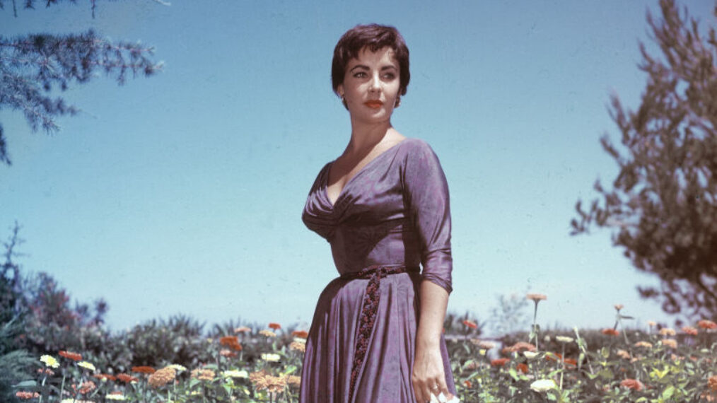 Full-length portrait of British-born actor Elizabeth Taylor as she stands in a garden and holds a handkerchief in her right hand, circa 1950s