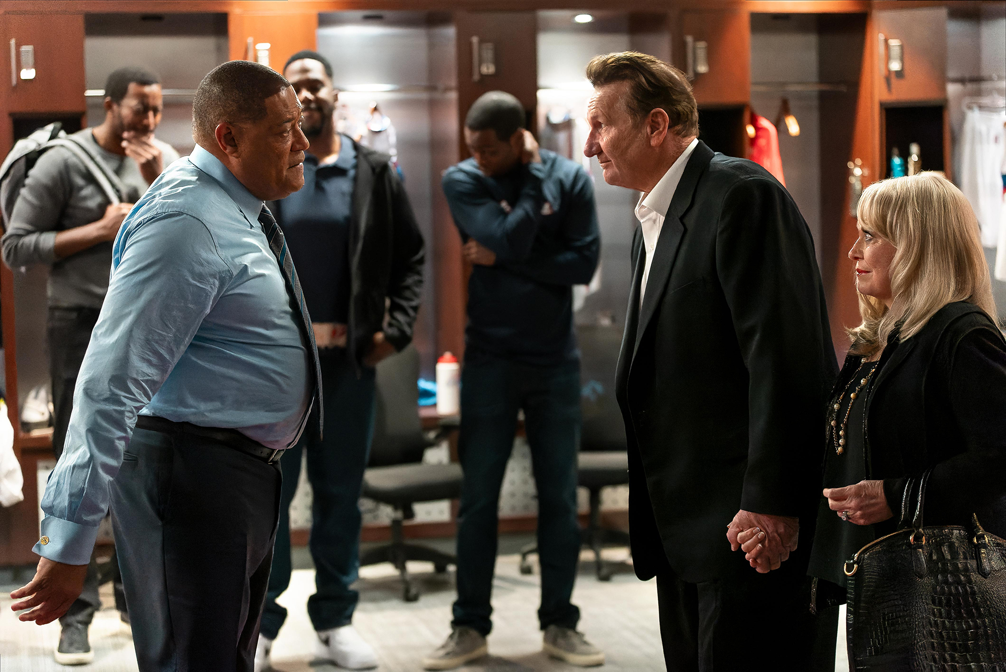 image from the FX/Hulu series "Clipped." From left to right in this scene within an NBA locker room are Laurence Fishburne as Coach Doc Rivers, Ed O'Neill as LA Clippers owner Don Sterling and Jacki Weaver as Shelly Sterling