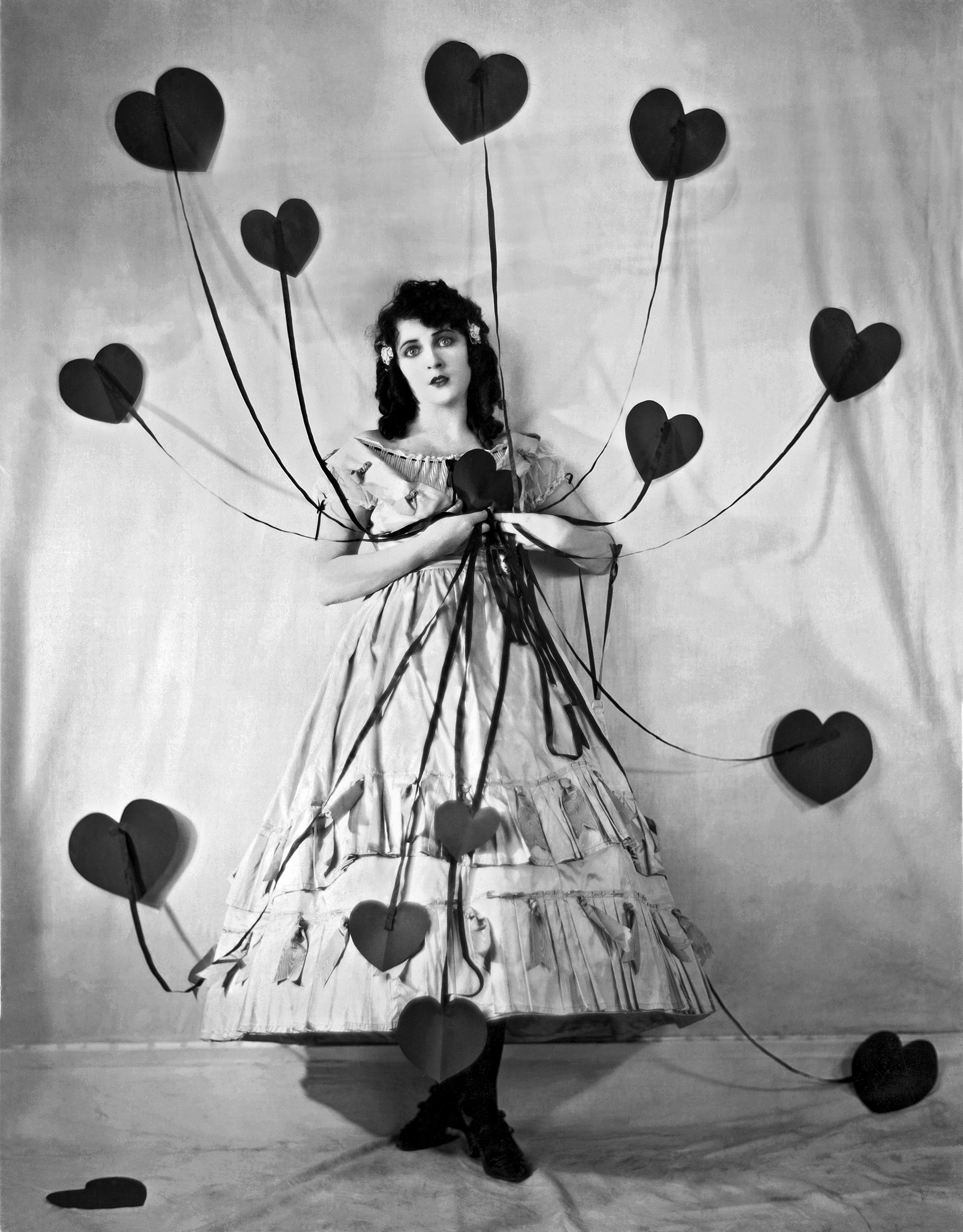 Portrait of American actress Jacqueline Logan as she poses for Valentine's Day with a number of hearts on ribbons, Hollywood, California, circa 1925.