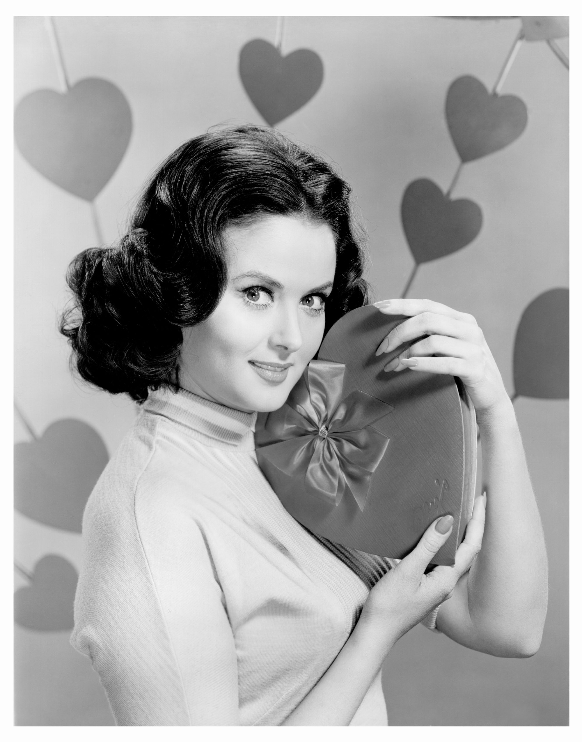 Actress and model Nancy Walters holds a heart-shaped box of chocolate on Valentine’s Day in a publicity shot from the the early 1960s.