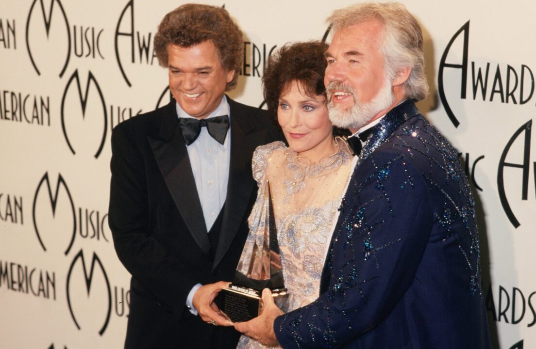 SANTA MONICA, CA - JANUARY 16: Country singer Loretta Lynn poses for a portrait with Conway Twitty (Left) and Kenny Rogers at the American Music Awards which were held at the Santa Monica Civic Auditorium on January 16, 1978 in Santa Monica, California. 