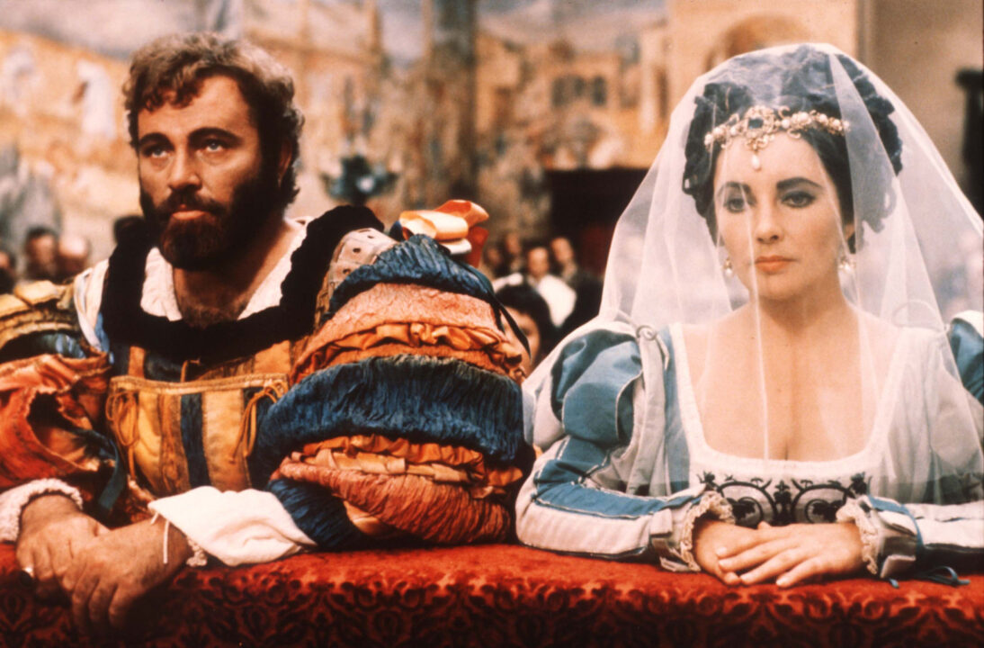Actors Elizabeth Taylor and Richard Burton kneel in a scene from the film "The Taming of the Shrew" 1973 in Italy. The film, based on Shakespeare's play of the same name, tells the story of two sisters and their family's struggle to find husbands for them.