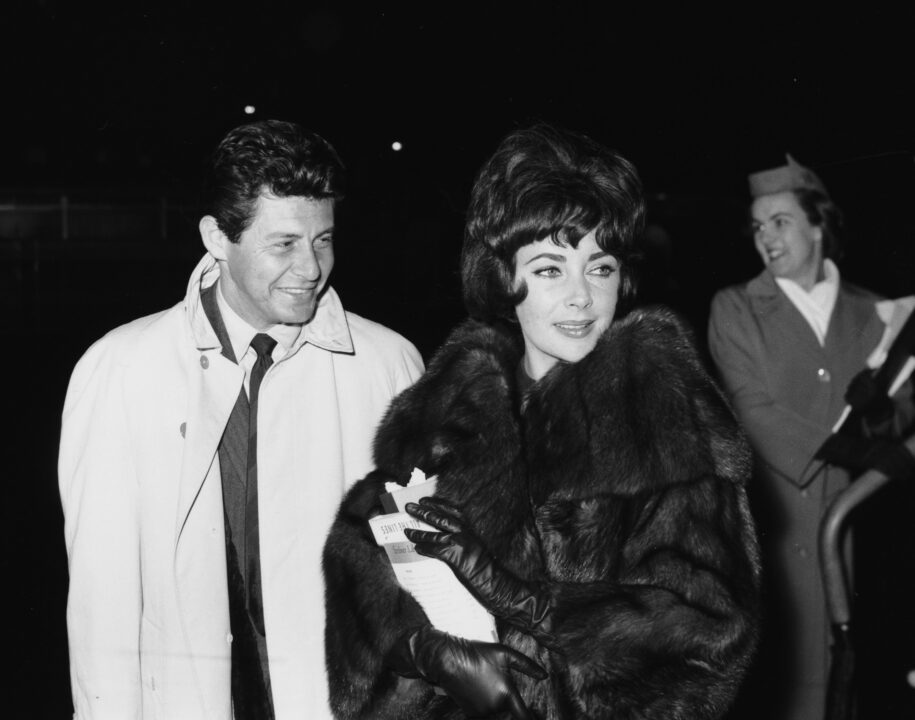 Actress Elizabeth Taylor, wearing a fur coat, and her husband, singer Eddie Fisher, January 5th 1961. 