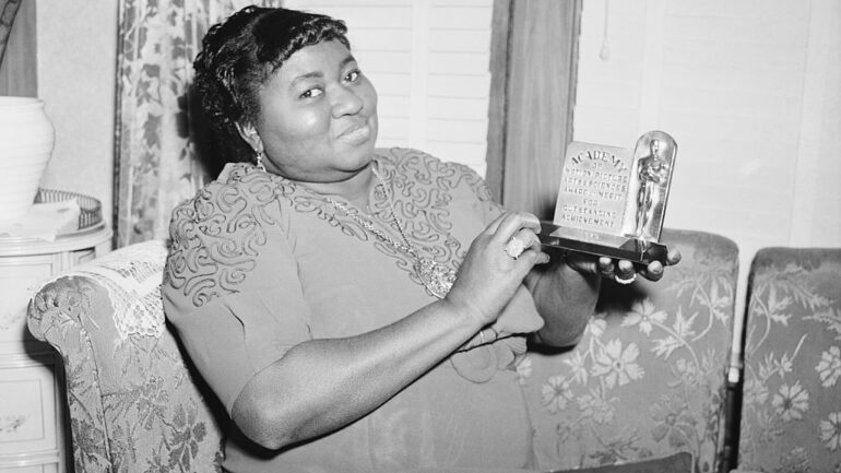 Actress Hattie Mc Daniel is shown with the statuette she received for her portrayal in